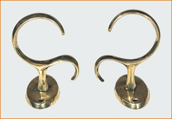 A pair of exceptionally large and bold brass jamb hooks with oval backplates